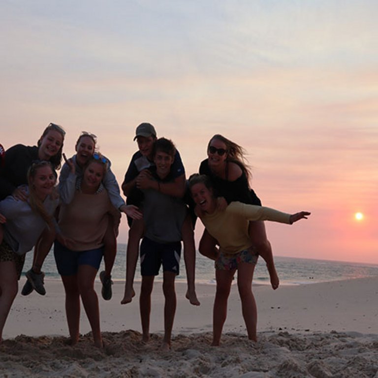 Freiwillige in Südafrika bei Sonnenuntergang am Strand